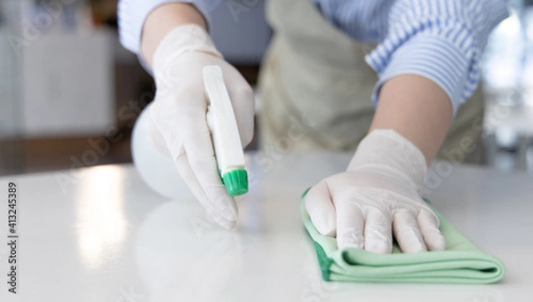 Fototapeta Close up Staff hand Restaurant workers are cleaning table and spraying disinfectants during the virus outbreak, Using cleaning solutions or using alcohol to kill germs in the restaurant.