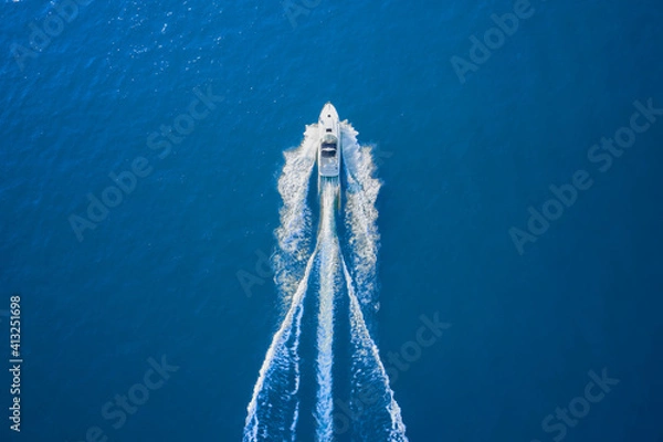 Fototapeta Motor boat in the sea. Aerial view luxury motor boat. Drone view of a boat sailing. Top view of a white boat sailing to the blue sea. Travel - image.