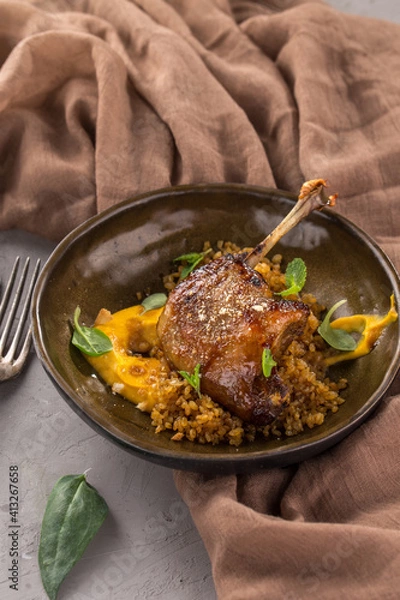 Obraz Duck confit Roasted duck leg with puree on brown plate on the table