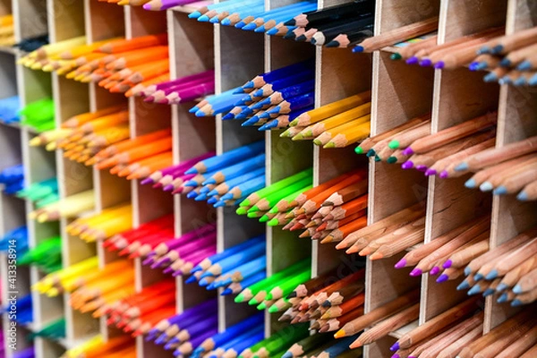 Fototapeta Bright multicolored pencils on the wooden shelves at the shop. Different colored pencils background. Selective focus. 