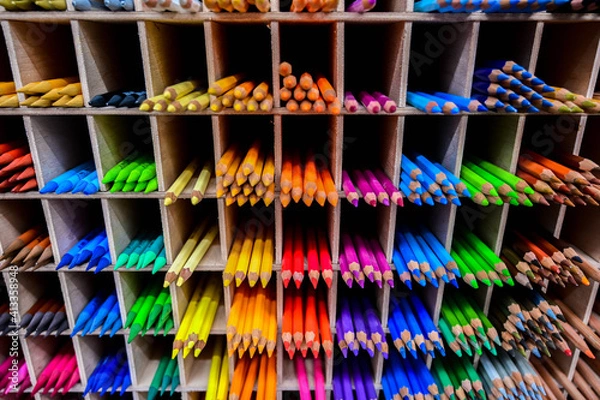 Fototapeta Bright multicolored pencils on the wooden shelves at the shop. Different colored pencils background. Selective focus. 