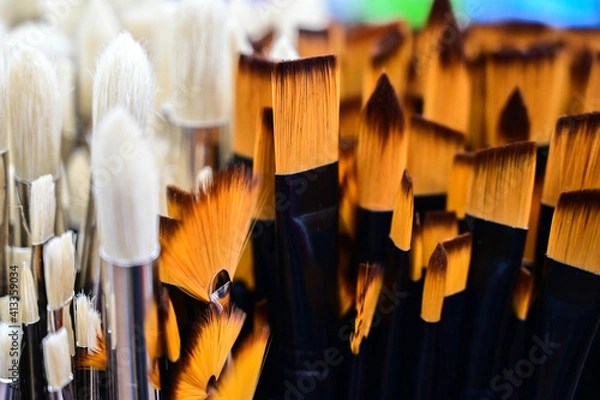 Fototapeta Stunning and sophisticated paint brushes in the shop. Natural squirrel brushes of different forms and sizes. Artist's tools on the blurred background. Black and white brushes.