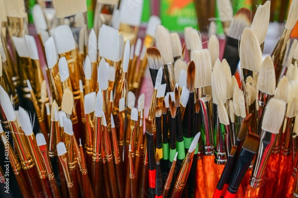 Fototapeta Stunning and sophisticated paint brushes in the shop. Natural squirrel brushes of different forms and sizes. Artist's tools on the blurred background. Black and white brushes.