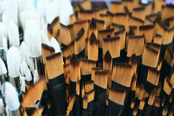 Fototapeta Stunning and sophisticated paint brushes in the shop. Natural squirrel brushes of different forms and sizes. Artist's tools on the blurred background. Black and white brushes.