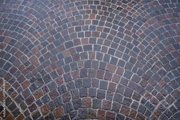 Fototapeta wet road pavement in gray porphyry cubes. background
