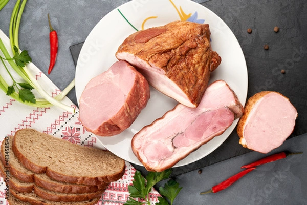 Fototapeta Assortment of meat products with lard on a platter without slicing. Still life of ham.
