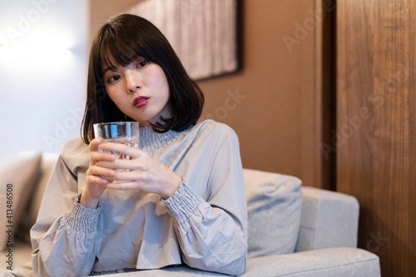 Fototapeta 寝室で水を飲む女性