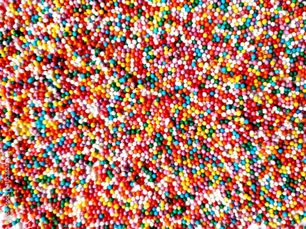 Fototapeta texture of multicolored sprinkles for Easter top view. different colors round small sugar balls of bright red blue and yellow colors