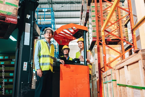 Fototapeta Working Team at warehouse. Manager man and asian woman warehouse worker standing to look at the camera.background driver at Warehouse forklift loader works with goods