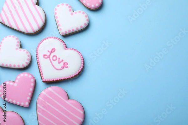 Fototapeta Delicious heart shaped cookies on light blue background, flat lay with space for text. Valentine's Day