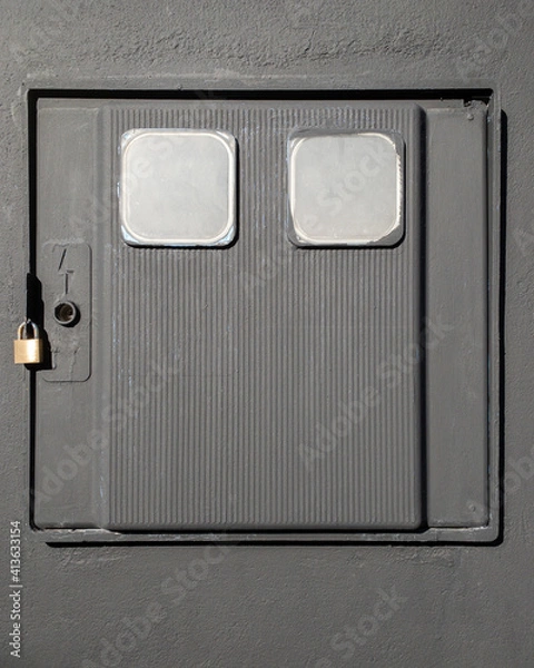 Fototapeta Gray box for electric meter with padlock on a wall