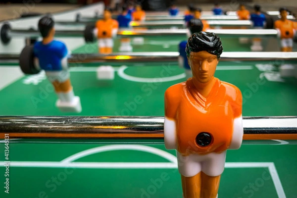 Fototapeta Extreme Close-Up of a Player with an Orange Jersey on a Foosball Table