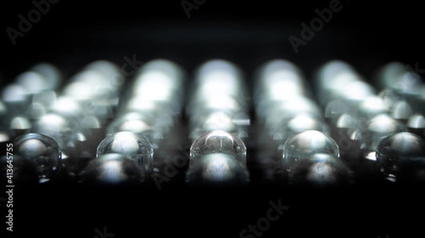 Fototapeta Moody, Shadow Extreme Close-Up of a Row of Small, Lit LED Light Bulbs