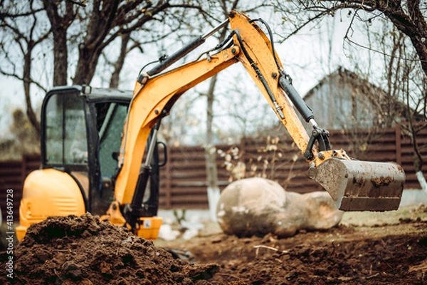 Fototapeta Landscaping works with mini excavator at home construction site. Terrain works