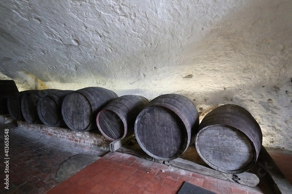 Fototapeta old wine barrels in an ancient cellar