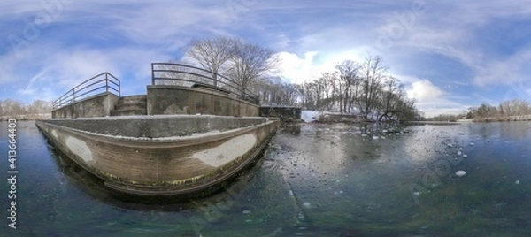 Fototapeta Panorama of a Ledge Next to an Ice-Covered Lake on a Cold, Winter Day with Blue Skies and Forrest in the Background