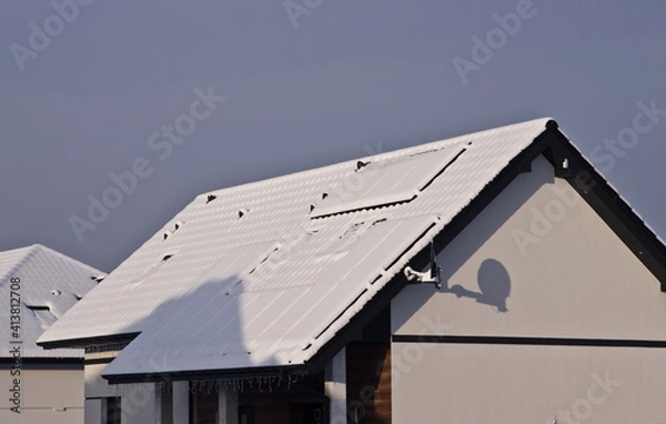 Obraz Roof of a house with solar panels completely covered with snow