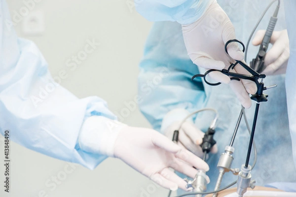 Fototapeta Surgeon performs laparoscopic surgery on the abdomen. Close-up of a laparoscope and doctor's hands
