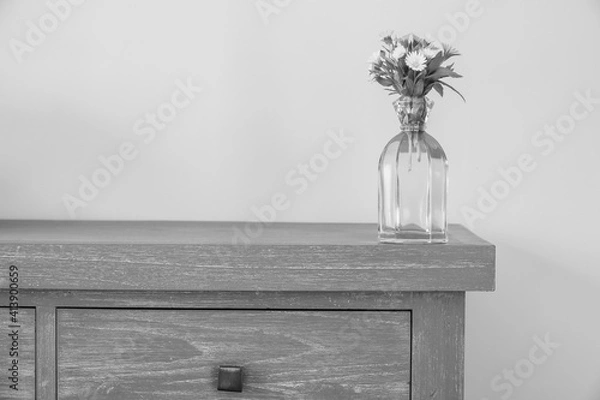 Fototapeta Interior decoration: bouquet of yellow wildflowers in a glass vase on gray wooden background