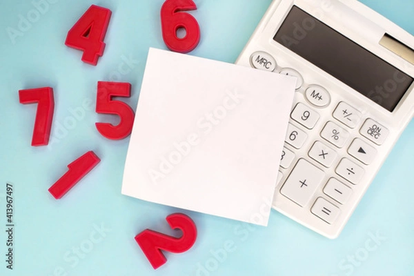 Fototapeta A white blank sheet lies on a white calculator near the scattered red numbers. The concept of education and teaching mathematics