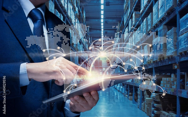 Obraz Businessman manager using tablet to plan, check, control of logistic transportation in country and Global. Man touch point of city connection line in world map to distribute product goods at warehouse