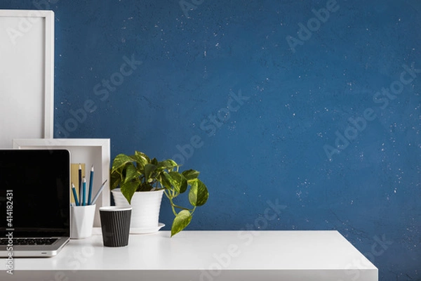 Obraz Home office desk with blue wall and white table mock up.	
