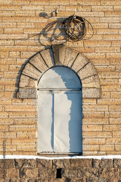 Obraz the door in the form of an arch is closed with a sheet of iron. old textured brick building