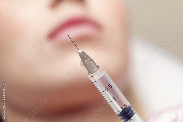 Fototapeta Close up Needle from an injection in a beauty salon. There is a small drop of liquid at the tip of the needle.