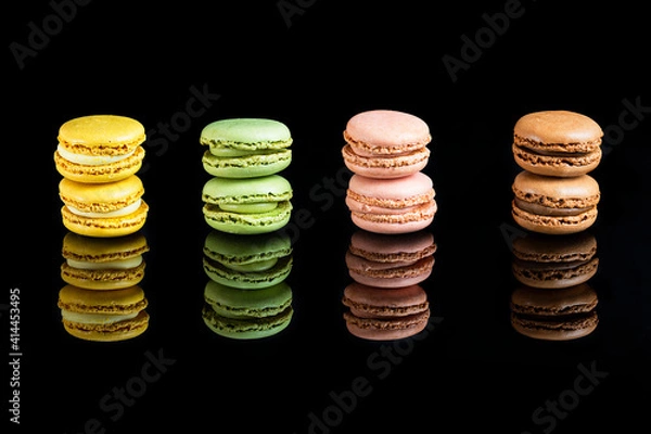 Obraz Multicolored macarons lined up on a black background