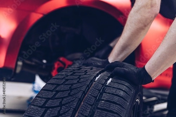 Fototapeta Changing car tire and wheel in the professional car mechanical service