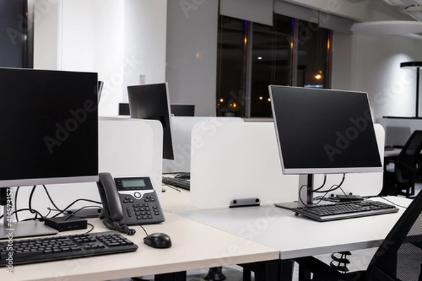 Obraz Empty modern office with computers and phone at night