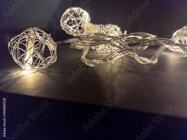Fototapeta Photo of New Year's lighting on a black background. Awesome garland decoration. Festive decoration for Christmas and New Year. Low key. View from above.
