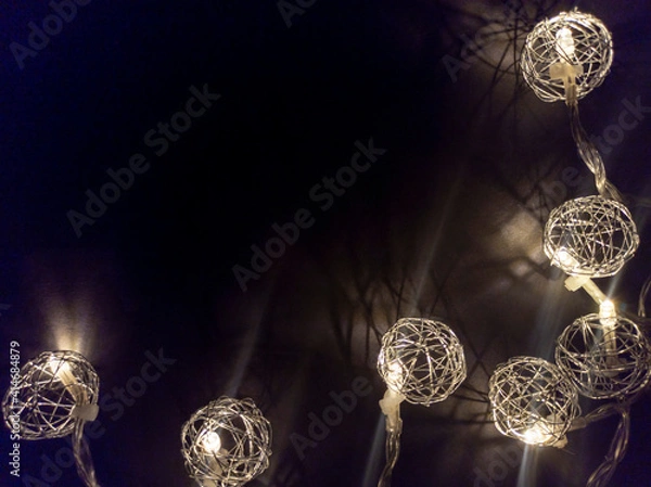 Fototapeta Photo of New Year's lighting on a black background. Awesome garland decoration. Festive decoration for Christmas and New Year. Low key. View from above.