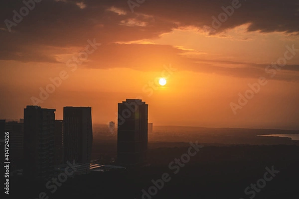 Fototapeta bright orange sunset over the city