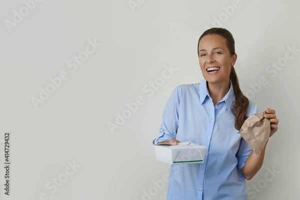Fototapeta Portrait shot of happy young woman receiving lunch meal box. 