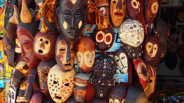 Fototapeta Selection of African masks carved from wood and decorated, some with seashells and others by being engraved