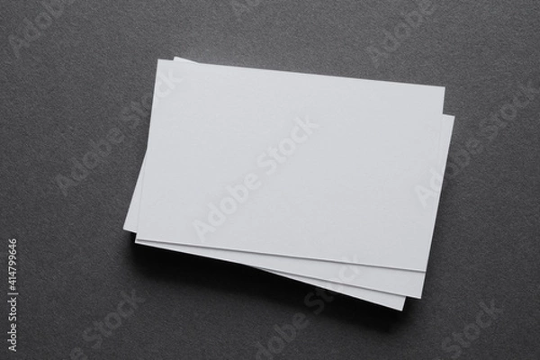 Fototapeta Mock up a stack of blank white cards ün a grey table, space for text or a template
