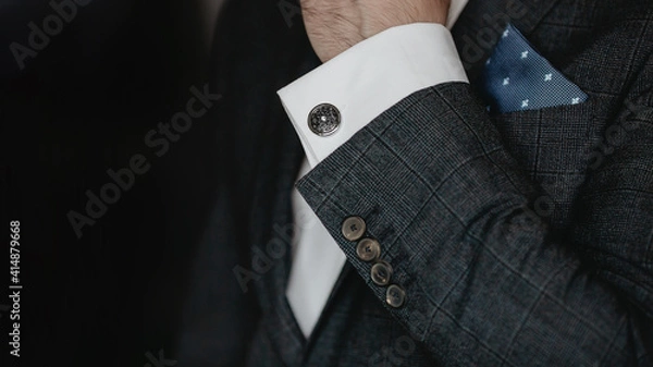 Obraz Hand men wears cufflinks close up.