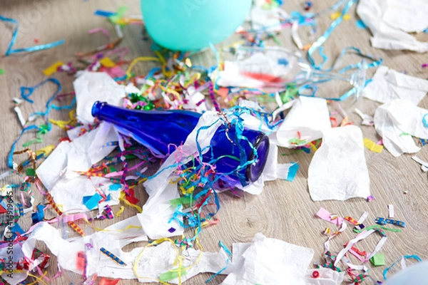 Fototapeta Top view of floor with after a party celebration with empty blue bottles, wine glass and party decorations, messy living room interior, After party chaos, birthday
