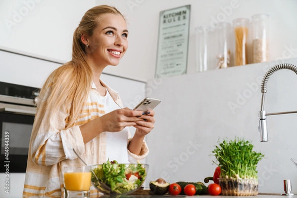 Fototapeta Portrait of a happy afro american woman using mobile phone