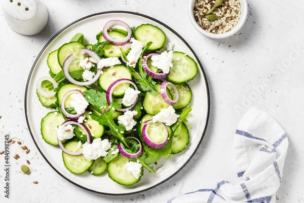 Fototapeta Feta red onion cucumber salad. Space for text, top view.