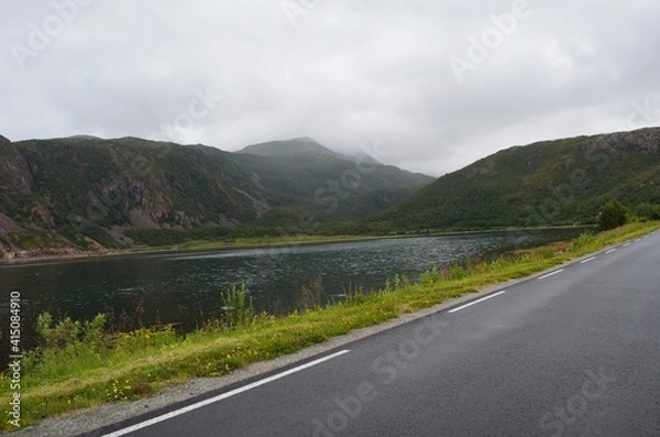 Fototapeta road in the mountains with fjord and clouds