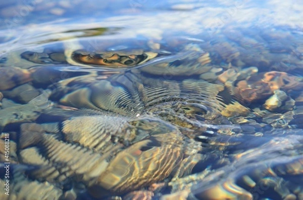 Fototapeta beautiful ripples on river flow over colorful stones in summer sunshine