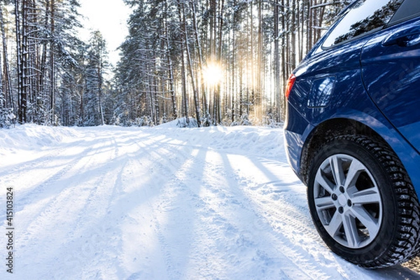 Fototapeta car on a winter road in a snowy forest, winter journey