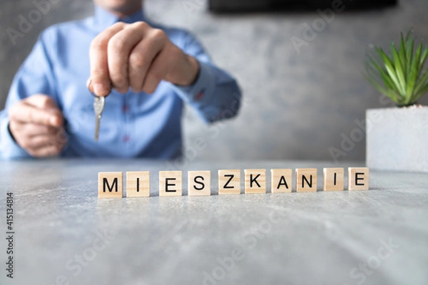 Fototapeta MIeszkanie, napis z liter. Mężczyzna trzymający klucze do nowego domu.