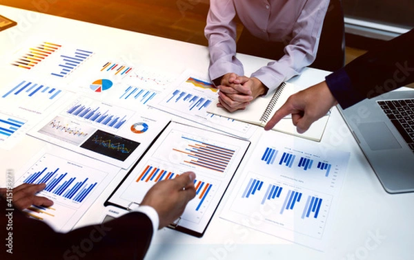 Fototapeta Team of business people working together in the meeting room office,
teamwork background charts and graphs banner, double exposure successful teamwork,business planning concept.
