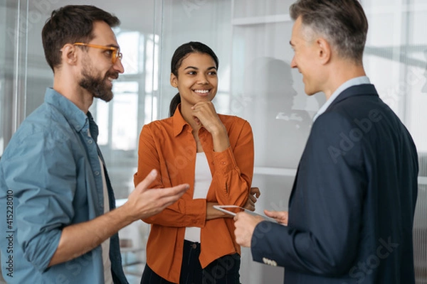 Fototapeta Group of multiracial business people talking, discussion start up project, brainstorming at workplace. Creative colleagues working together in modern office. Teamwork concept 