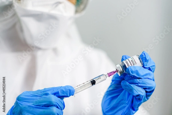 Fototapeta Coronavirus COVID-19 vaccine vial in female doctor hands and holds  injection syringe vaccine for coronavirus cure, Corona Virus Treatment, Medicine and Healthcare concept. Selection focus on vial..