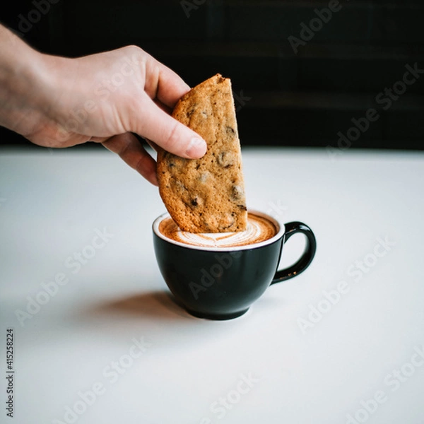 Obraz hand dipping cookie into coffee