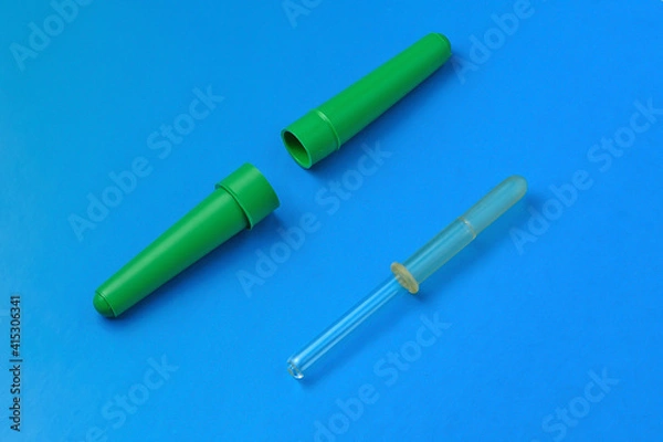 Fototapeta Medical pipette with case on blue background close-up
